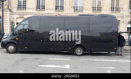 Minibus touristique noir en attente avec porte arrière ouverte parking dans la rue tour Banque D'Images