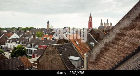 Toits du centre-ville de Maastricht le dimanche après-midi. Paysage urbain avec toits de tuiles et cheminées de vieux bâtiments Banque D'Images