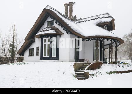 Cottage de chaume couvert de neige en hiver en Angleterre Banque D'Images