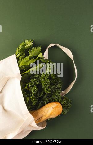 Sac en toile blanche avec baguette et légumes de salade verts et espace de copie sur fond vert Banque D'Images