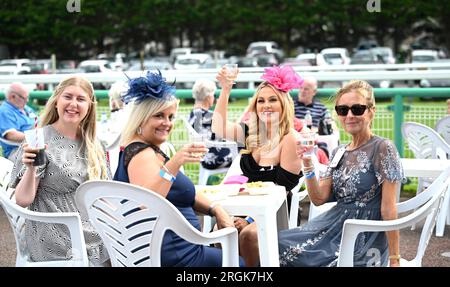 Brighton Royaume-Uni 10 août 2023 - Cheers beaucoup de chapeaux et robes fabuleux sur l'exposition que les coureurs profitent du temps chaud et ensoleillé à Brighton courses Ladies Day pendant leur Star Sports 3 jours Festival of Racing : Credit Simon Dack / Alamy Live News Banque D'Images