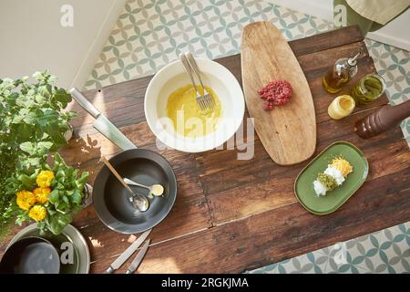 Vue de dessus d'un assortiment d'ingrédients savoureux disposés sur la table en bois pour la cuisson appétissante steak tartare dans la cuisine Banque D'Images