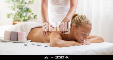 Beatiful Woman profite d'un massage relaxant du dos dans le centre de spa cosmétologie. Banque D'Images