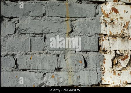 Mur gris. Briques peintes enlevées grossièrement. Détails de l'ancien bâtiment. Vieille peinture. Banque D'Images