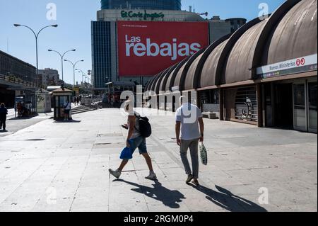 Les piétons et les acheteurs sont vus à l'extérieur du plus grand magasin espagnol El Corte Ingles comme une grande saison des soldes d'été (Rebajas en espagnol) panneau d'affichage pend en arrière-plan en Espagne. Banque D'Images