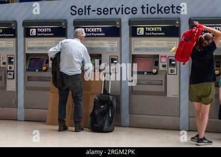 Waterloo, Londres, Royaume-Uni. 10 août 2023. Passagers utilisant des distributeurs automatiques de billets en libre-service à la gare de Waterloo à Londres. Un horaire réduit était en vigueur aujourd'hui sur South Western Railway en raison de l'action syndicale des membres du syndicat ASLEF interdisant les heures supplémentaires. Les trains à destination de Londres depuis Windsor ne circulaient qu'une fois par heure. Il a été annoncé que la majorité des guichets des gares ferrées devaient fermer. Crédit : Maureen McLean/Alamy Live News Banque D'Images