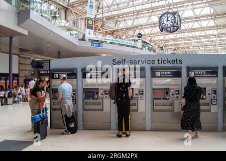 Waterloo, Londres, Royaume-Uni. 10 août 2023. Passagers utilisant des distributeurs automatiques de billets en libre-service à la gare de Waterloo à Londres. Un horaire réduit était en vigueur aujourd'hui sur South Western Railway en raison de l'action syndicale des membres du syndicat ASLEF interdisant les heures supplémentaires. Les trains à destination de Londres depuis Windsor ne circulaient qu'une fois par heure. Il a été annoncé que la majorité des guichets des gares ferrées devaient fermer. Crédit : Maureen McLean/Alamy Live News Banque D'Images