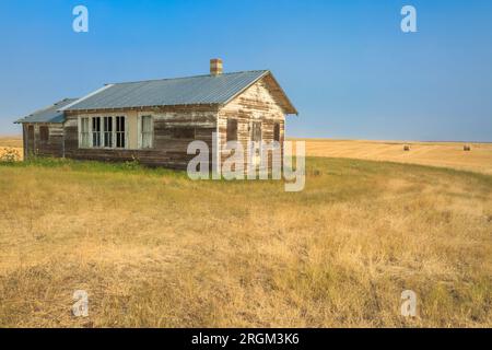 vieille école dans la prairie au-dessus des champs de blé près de fort benton, montana Banque D'Images