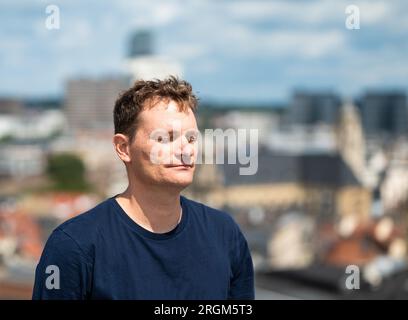 Portrait d'un homme blanc de 44 ans, les yeux fermés avec la ville en arrière-plan, Bruxelles, Belgique Banque D'Images