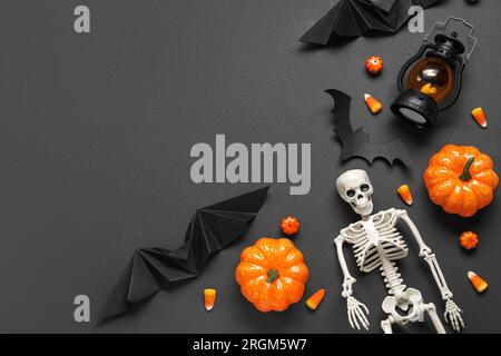 Composition avec des cors de bonbons savoureux, lanterne, squelette et décor d'Halloween sur fond brun Banque D'Images