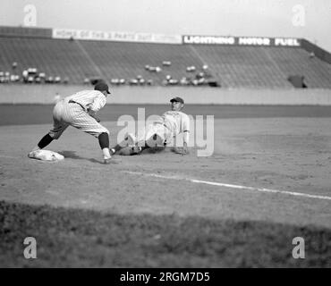 1925 Washington Senators : Yankees Babe Ruth en cinquième manche essayant de passer de la première à la troisième sur le single de Lou Gehrig. Le troisième joueur de base des sénateurs est Ossie Bluege. Les Yankees ont gagné 3-2 Banque D'Images