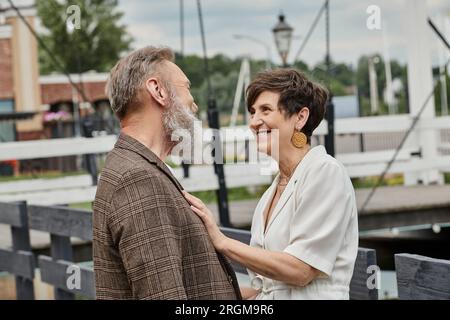 heureuse femme âgée embrassant l'homme, se regardant à l'extérieur, l'amour et la romance, couple âgé Banque D'Images