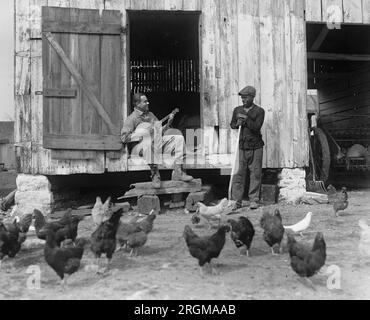 Un homme afro-américain dans une cour jouant un banjo ca. 1927 Banque D'Images