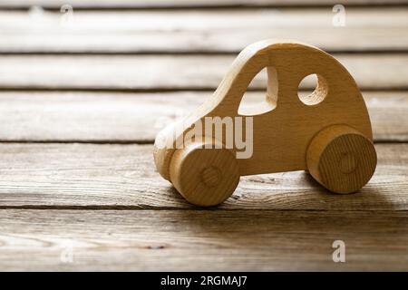 Petite vieille voiture en bois sur une table en bois gros plan Banque D'Images