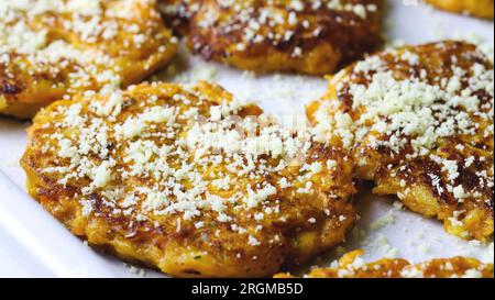 Gros plan de beignets de patate douce garnis de parmesan. Aliment à base de plantes. Côtelettes de carottes aux herbes et persil. Frites Batat ou citrouille parmigiano fri Banque D'Images