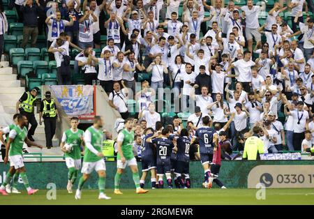 Ismaji Beka du FC Luzern célèbre avoir marqué le premier but de son équipe avec ses coéquipiers devant les supporters extérieurs alors que les joueurs d'Hibernian semblent frustrés lors du match de qualification de la troisième UEFA Europa Conference League, première étape à Easter Road, Édimbourg. Date de la photo : jeudi 10 août 2023. Banque D'Images