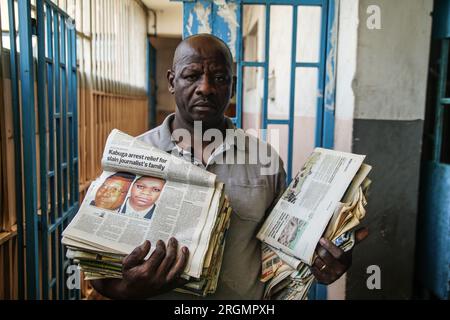 Josephat Mureithi, 54 ans, frère du journaliste kenyan tué William Munuhe, porte de vieux journaux kenyans qui ont couvert l'histoire du fugitif présumé du génocide rwandais Felicien Kabuga dans son atelier de réparation d'appareils électroniques dans la ville de Nakuru. La famille du regretté journaliste kenyan William Munuhe, tué le 14 janvier 2003, alors qu'il aidait la police et le FBI à retrouver Felicien Kabuga. Felicien Kabuga, 87 ans, le cerveau présumé du génocide rwandais malade, devrait être libéré à la suite du mécanisme international des Nations Unies chargé d'exercer les fonctions résiduelles des Nations Unies pour Crimina Banque D'Images