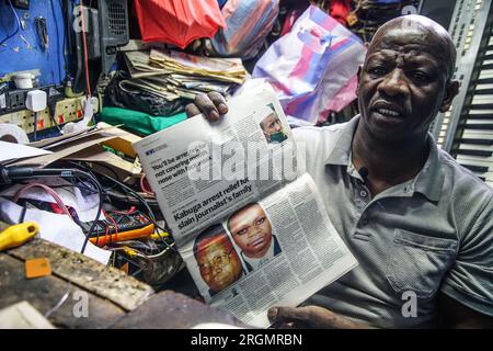 Josephat Mureithi, 54 ans, frère du journaliste kenyan tué William Munuhe, expose un vieux journal kenyan qui a couvert l'histoire du fugitif présumé du génocide rwandais Felicien Kabuga dans son atelier de réparation d'appareils électroniques dans la ville de Nakuru. La famille du regretté journaliste kenyan William Munuhe, tué le 14 janvier 2003, alors qu'il aidait la police et le FBI à retrouver Felicien Kabuga. Felicien Kabuga, 87 ans, le cerveau présumé du génocide rwandais malade, devrait être libéré à la suite du mécanisme international résiduel des Nations Unies pour le CRIM Banque D'Images