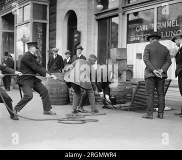 Officiers et agents menant une descente d'alcool, confisquant l'alcool pendant la prohibition ca. 1923 Banque D'Images