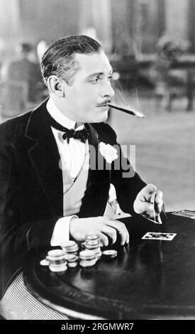 Homme, avec le porte-cigarette dans la bouche, jouer aux cartes ca. 1930 Banque D'Images