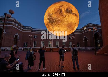 Londres, Royaume-Uni. 10 août 2023. Mars : War & Peace de Luke Jerram. Une réplique rotative de sept mètres de large de l'installation de mars par Luke Jerram actuellement exposée à Jubilee Square à Kensington. La sculpture monumentale, suspendue et éclairée à l'intérieur a été construite à l'aide d'images de la NASA qui présentent des images détaillées à 120 dpi de la surface martienne. Environ un million de fois plus petit que la planète actuelle, chaque centimètre de la sculpture sphérique représente 10 kilomètres de la surface de Mars. Crédit : Guy Corbishley/Alamy Live News Banque D'Images