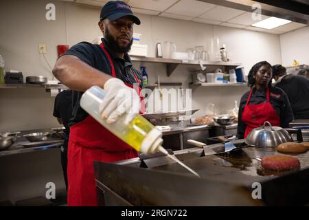 Reportage : SNAP emploi et formation au café Reconcile à la Nouvelle-Orléans LA (février 2023) - les formateurs avocats et les stagiaires au café Reconcile préparent de la nourriture lors d'un service de déjeuner à la Nouvelle-Orléans, Louisiane, le 16 février 2023. Banque D'Images