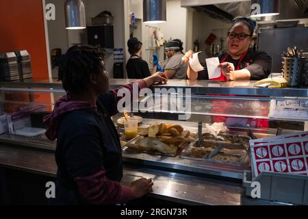 Reportage : SNAP Employment and Training at Cafe Reconcile, un restaurant soul food, à la Nouvelle-Orléans LA (février 2023) - le chef de la cuisine au café Reconcile lit les commandes de nourriture des clients et briefe un stagiaire, 16 février 2023. Banque D'Images