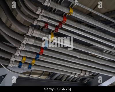 Système de conduit électrique et tube de câble électrique installé sur le plafond d'un bâtiment. Infrastructure industrielle. Installation efficace du câblage électrique Banque D'Images