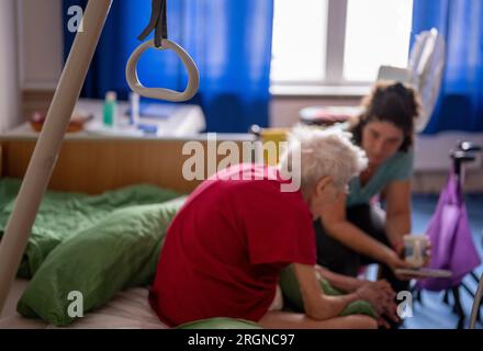 Berlin, Allemagne. 31 juillet 2023. La soignante Ramona Rössner écoute sa patiente, Brigitte Richter, âgée de 97 ans, qui a besoin de soins, lors d’une visite à domicile. Crédit : Monika Skolimowska/dpa/Alamy Live News Banque D'Images