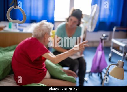 Berlin, Allemagne. 31 juillet 2023. La soignante Ramona Rössner écoute sa patiente, Brigitte Richter, âgée de 97 ans, qui a besoin de soins, lors d’une visite à domicile. Crédit : Monika Skolimowska/dpa/Alamy Live News Banque D'Images