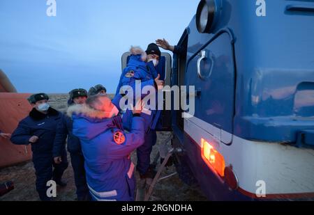 Reportage : Expedition 66 Soyouz Landing (Mars 2022) - l'astronaute de l'expédition 66 de la NASA Mark Vande Hei donne un pouce levé alors qu'il est aidé à bord d'un véhicule tout terrain russe par le représentant du bureau des astronautes de la NASA, l'astronaute Drew Feustel, qui l'emmènera à un hélicoptère en attente. Banque D'Images