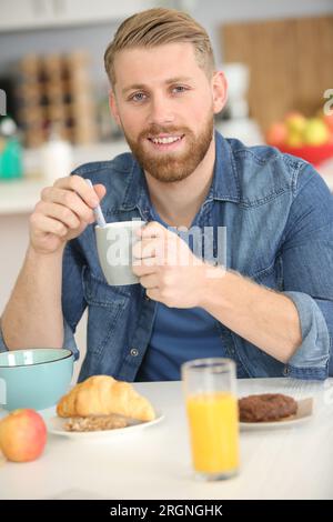 homme adulte en bonne santé prenant le petit déjeuner dans l'appartement Banque D'Images