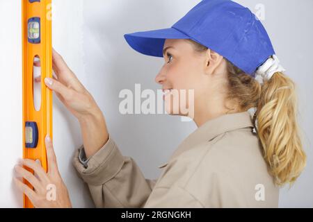 belles femmes faisant une marque sur le mur avec le niveau Banque D'Images