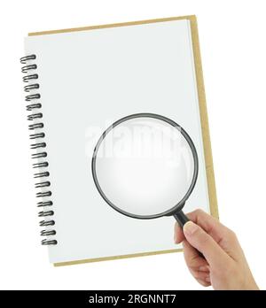 Main tenant la loupe sur un cahier isolé sur fond transparent blanc, vue de dessus Banque D'Images