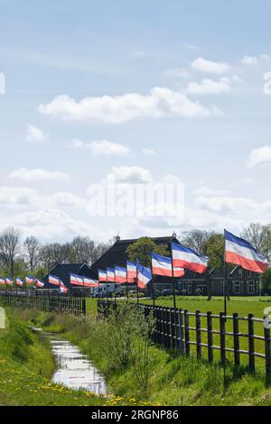 Une rangée de drapeaux néerlandais rouge blanc et bleu à l'envers aux pays-Bas. Protestations contre la réduction forcée du bétail en raison des émissions de CO2. Banque D'Images