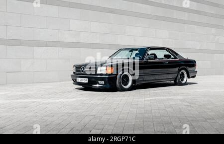 Classique Mercedes-Benz W126 noir devant le mur gris Banque D'Images