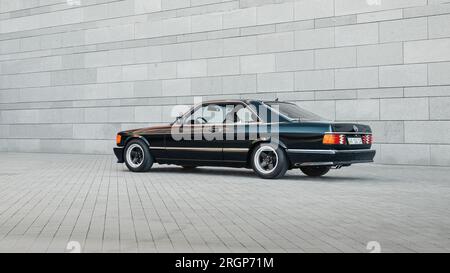 Classique Mercedes-Benz W126 noir devant le mur gris Banque D'Images
