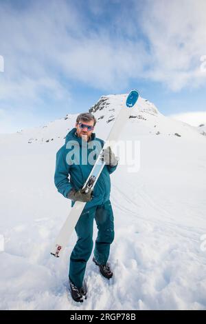 skieur jouant de la guitare d'air sur son ski, montagne en arrière-plan Banque D'Images