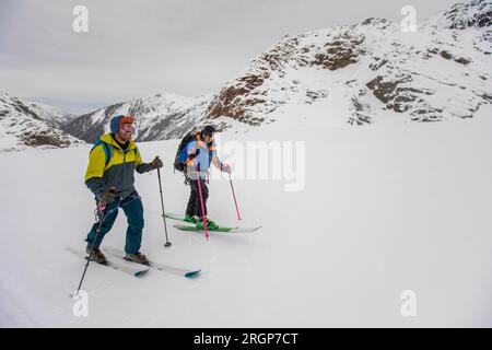 Amis rient, sourient et font du ski ensemble en plein air Banque D'Images