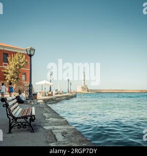 Promenade maritime dans le port de la Canée avec vue sur le phare et le brise-lames. Quelques bancs avec vue sur le port placés le long du remblai. Banque D'Images