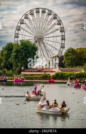 Les gens profitent du soleil sur le lac marin à Southport, dans des pédalos de cygne, des bateaux. Banque D'Images