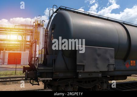 Wagon-citerne près d'une raffinerie de pétrole. Wagon de chemin de fer pour le transport de marchandises liquides et gazeuses. Équipement de zone industrielle. Banque D'Images