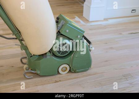 parquet en bois sol par charpentier utilisant ponceuse de plancher dans la maison nouvellement construite Banque D'Images