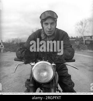 Motocycliste dans les années 1950 Un jeune homme habillé de la manière typique des motocyclistes dans les années 1950 Tout en cuir. Bottes, pantalons et vestes en cuir. Il est assis sur sa moto. Suède 1953. Il est l'acteur Sven-Eric Gamble, 1924-1976. Kristoffersson réf. BM72-4 Banque D'Images