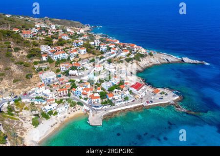 Charmant village de pêcheurs grec d'Armenistis dans un matin calme d'été. Port avec plage locale dans l'eau claire transparente à Ikaria, Grèce Banque D'Images