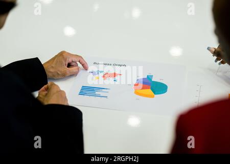 Cultivez diverses personnes travaillant sur papier avec graphique d'affaires Banque D'Images