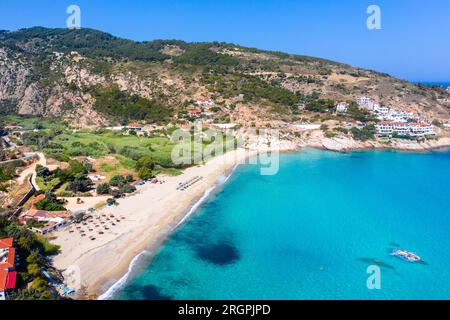 Charmant village de pêcheurs grec d'Armenistis dans un matin calme d'été. Port avec plage locale dans l'eau claire transparente à Ikaria, Grèce Banque D'Images