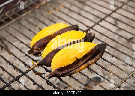 Bananes sur un grill dans un stand de Street food à Bangkok. Banque D'Images