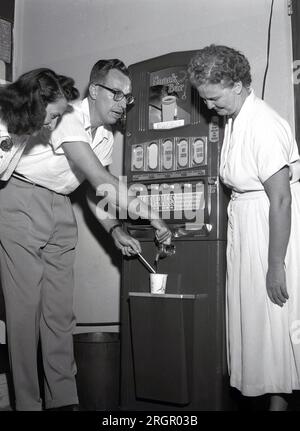 Années 1950, historique, nouveau distributeur automatique, 'snack Bar ; États-Unis. Boissons disponibles, café noir, café à la crème, soupe chaude de Coca et bouillon de poulet. Chaque boisson chaude coûte 10 cents et on pourrait insérer un centime ou deux nickels! La première véritable utilisation commerciale des distributeurs automatiques a été développée à la fin des années 1880 pour vendre du chewing-gum sur les quais de chemin de fer, avec ceux proposant des boissons gazeuses à venir au début des années 1900 Les vendeurs de café et de boissons chaudes ont commencé à apparaître à partir de la fin des années 1940 On dit que le premier distributeur automatique a été inventé par Hero Alexandria dans le premier centre pour distribuer de l'eau bénite. Banque D'Images