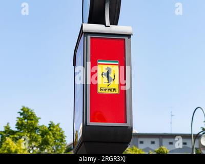 Ferrari logo signe du constructeur automobile italien comme publicité dans la ville. La marque de voitures de sport de luxe est célèbre et exclusive. Banque D'Images